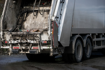 Fototapeta premium Garbage collector loading waste on the street