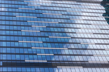 Windows of an office building with reflection of sky and clouds