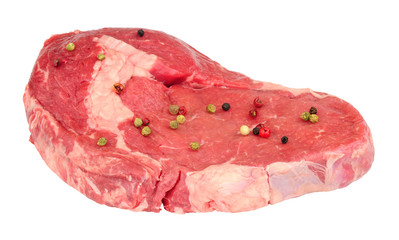 Fresh raw rib eye beef steak with pepper corns isolated on a white background