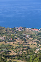 Fototapeta na wymiar Coastal town lying on the island of Vis on the Adriatic Sea, view on Church of Saint Nicholas, Komiza, Croatia