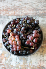 Fresh autumn homemade grapes in a bowl. Wine blue and pink grapes. Selective focus. Macro.