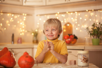 happy cute boy 5-6 years old makes gingerbread cookie from the dough in the kitchen for Halloween