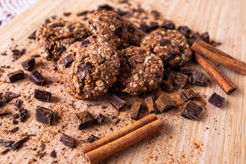 Chocolate cookies on wooden table with cinnamon sticks. Autumn style food photo.