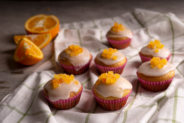 Candied fruit orange muffins on a white towel.