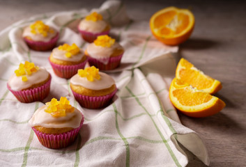 Candied fruit orange muffins on a white towel.