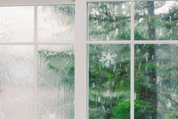 window inside with raining outside and blue tree for background
