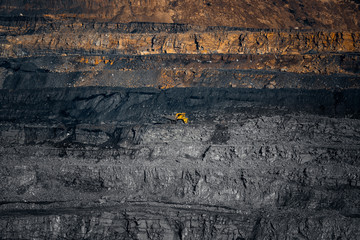 Open mine minerals mining of coal, gold, diamonds, copper. Scale of quarry, large yellow dump truck...
