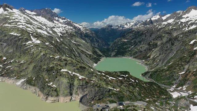 Aerial view of Grimsel Pass in Swiss Alps, picturesque scenery of snowy mountains and lake Grimselsee (hydroelectric reservoir) during spring thaw - landscape panorama of Switzerland from above,Europe
