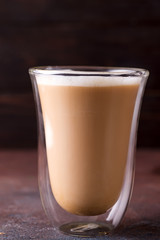 Glass cup of coffee latte on stone dark table