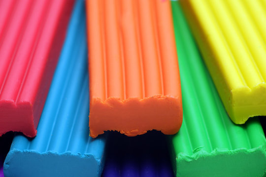 Red, blue,orange, green and yellow plastic clay sticks macro view,
