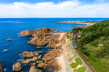 青森県 深浦町にある行合崎付近の奇岩沿いを走行するリゾート列車を俯瞰撮影