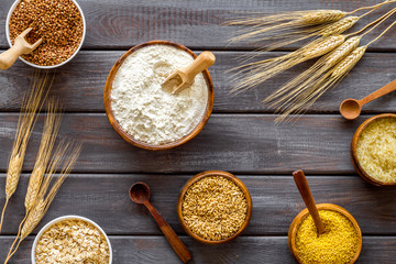 Healthy food concept. Cereals in bowls on dark wooden background top view