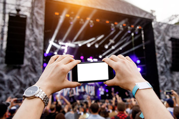 Smartphone in hands on music show.