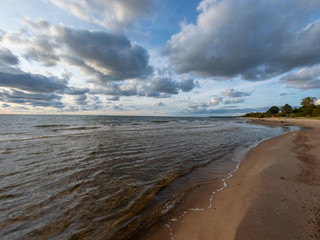 seascape image of the sea with cloudy sky before sunset,  stones and  of light before sunset, beautiful sunny day and quiet sea. baltic sea, Tuja beatch, Latvia