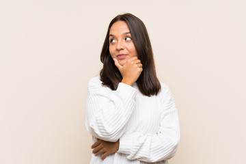 Fototapeta premium Young brunette woman with white sweater over isolated background thinking an idea