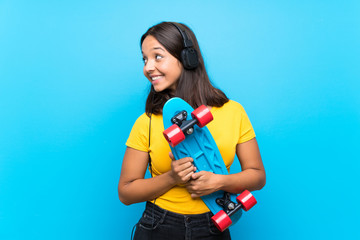 Young skater woman over isolated blue background