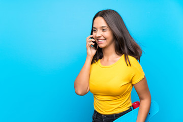 Fototapeta premium Young skater woman over isolated blue background