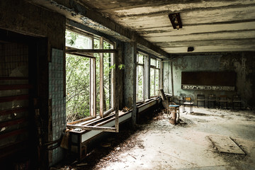 abandoned classroom with dirty chairs in school