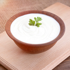 Bowl of Greek yogurt.Delicious breakfast. Homemade yogurt on a wooden tray, top view