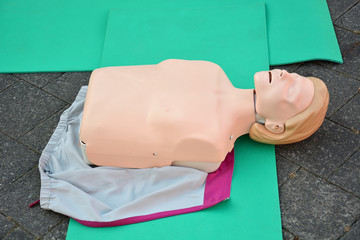 CPR first aid dummy training on the street. Plastic mannequin doll.