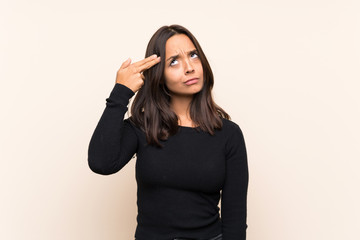 Young brunette woman with white sweater over isolated background with problems making suicide gesture