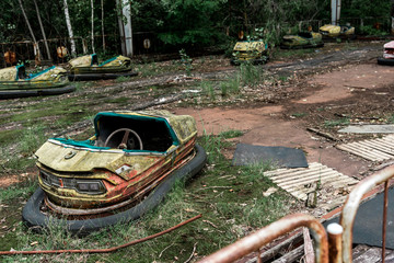 selective focus of abandoned and damaged bumper cars in amusement park