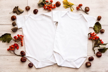 Mockup of two white baby bodysuit shirts in autumn style