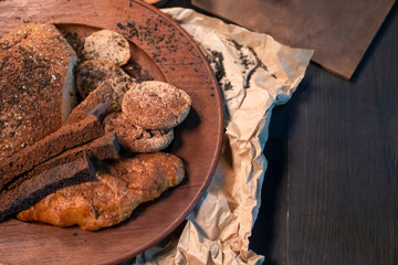 Selective focus of Brown bread in wooden dish on table in the dark grunge style.