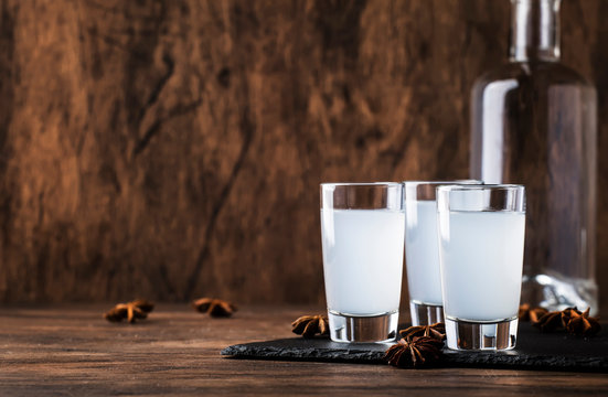 Ouzo - Greek anise brandy, traditional strong alcoholic drink in glasses on the old wooden table, place for text