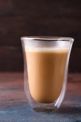 Glass cup of coffee latte on stone dark table