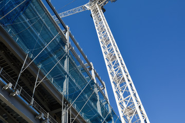 Fototapeta premium Construction Crane in operation working on Steel framed building.