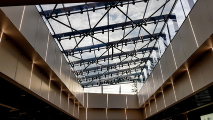 Structural glazing of the facade. Abstract background with glass ceiling elements in a modern building. view of the blue sky through a glass window, separated by lattice elements.