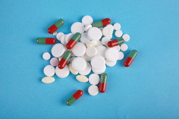 Fototapeta na wymiar medical pills and capsules top view on blue background. Medical concept of treatment diseases, sale of tablets, tablets in blister packs,addiction from drugs