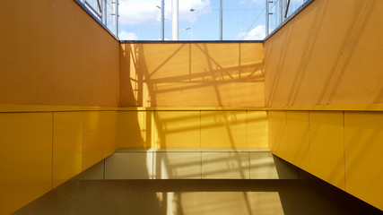 light rail station. Design of a bus stop and a pedestrian underpass with steps and railings made of yellow panels and a glass roof.