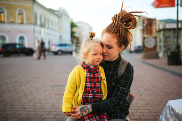 hipster mother gently consoles and embrace child