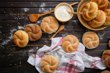 assortment of kaiser rolls on a wooden table