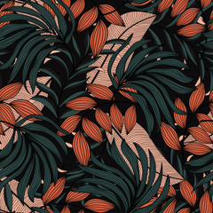 Trendy seamless tropical pattern with beige and green leaves and plants on black background. Beautiful exotic plants. Modern abstract design for fabric, paper, interior decor.