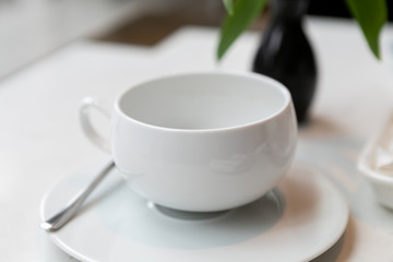 Fototapeta na wymiar White empty tea cup in restaurant 
