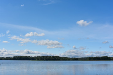 Lake, sky and dark forest in the far