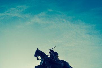 Silhouette of an old statue of a Japanese horseback samurai