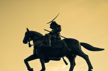 Silhouette of an old statue of a Japanese horseback samurai