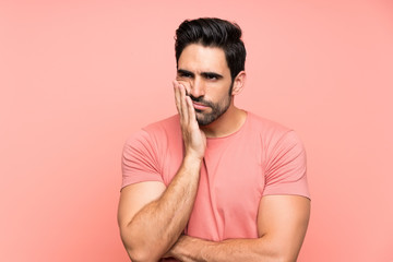 Handsome young man over isolated pink background unhappy and frustrated