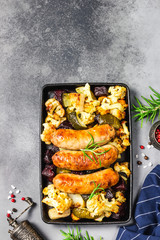 One pan grilled sausages and vegetables. Top view, copy space.