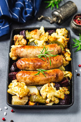 Sheet pan dinner, baked vegetables, turkey sausages. Selective focus, copy space.