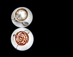 Hot art Mocha Coffee in two cups on black table. Image on top view.