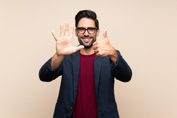 Handsome young man over isolated background counting six with fingers