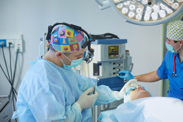 Several doctors surrounding patient on operation table during t