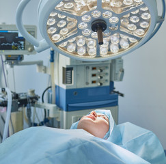 Several doctors surrounding patient on operation table during t