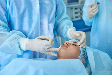 Several doctors surrounding patient on operation table during t
