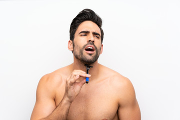 Fototapeta premium Man shaving his beard over isolated white wall